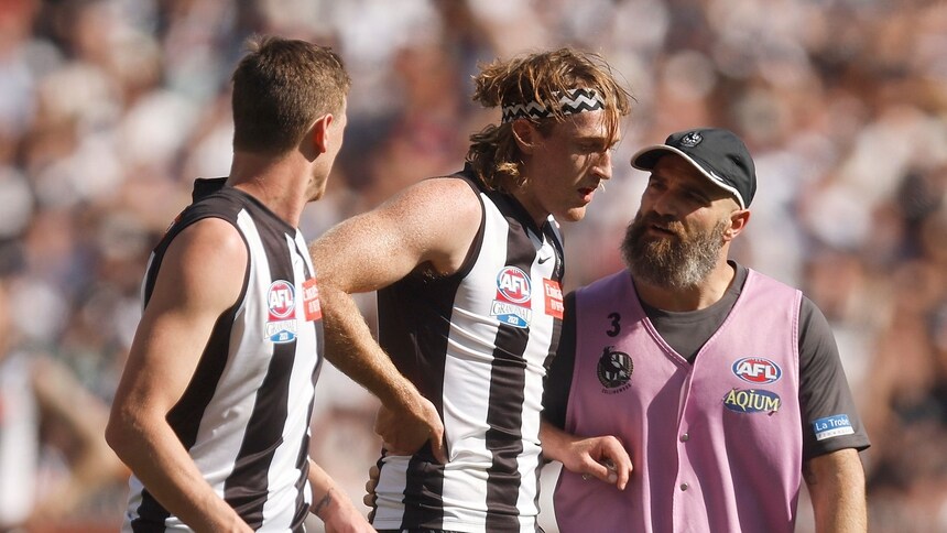 Collingwood's Nathan Murphy is helped from the ground in the 2023 Toyota AFL Grand Final. Picture: AFL Photos