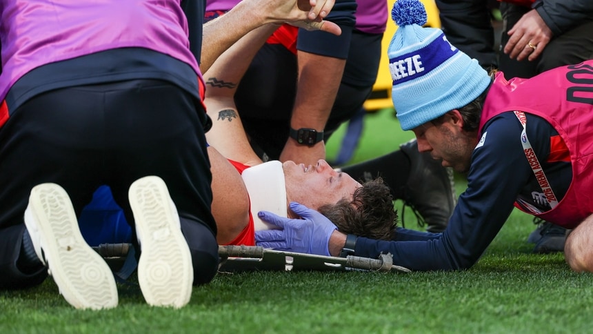 Brody Mihocek is treated by medicos and trainers after suffering a neck injury in round 13, 2026. Picture: AFL Photos